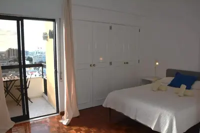 a bedroom with a white bed and a balcony at Blife Chelsya private rooms in Faro