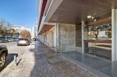 a sidewalk next to a building with a car parked on the street at Casa Alameda in Faro