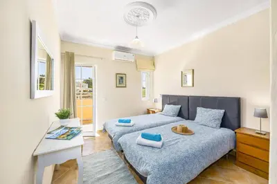 a bedroom with two beds and a desk in it at Villa Graca by Villa Plus in Albufeira