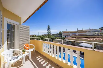 a balcony with chairs and a view of a building at Villa Graca by Villa Plus in Albufeira
