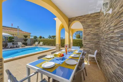 a patio with a table and a swimming pool at Villa Graca by Villa Plus in Albufeira