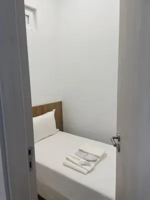 a small bed with white sheets and towels on it at Casa Tapada do Bento I- Albufeira in Albufeira