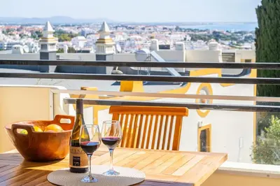 a table with two glasses of wine on a balcony at White Studio - Ocean View in Albufeira