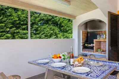 a table with plates and bowls of fruit on it at Villa Lurdes by Villa Plus in Galé