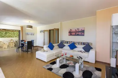 a living room with a white couch and blue pillows at Villa Lurdes by Villa Plus in Galé