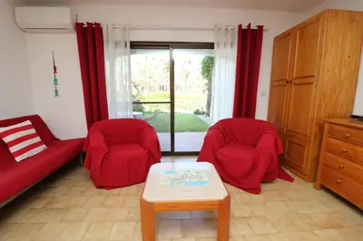 a living room with two red chairs and a table at Studio Camélia 68 at São Rafael Beach - Albufeira in Albufeira