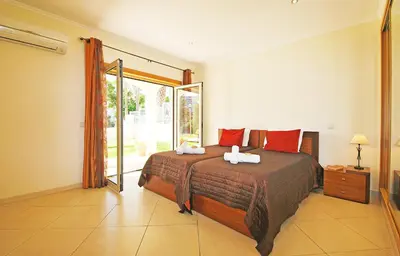 a bedroom with a bed and a sliding glass door at Villa Anna by Algarve Vacation in Albufeira