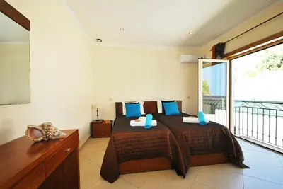 a bedroom with a large bed and a balcony at Villa Anna by Algarve Vacation in Albufeira