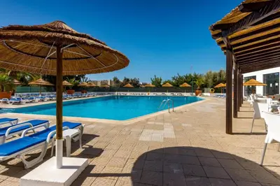 a swimming pool with chairs and an umbrella at Apartment Atlantic Sea by Algarve Vacation in Albufeira