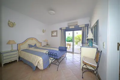 a bedroom with a bed and a table and chairs at Villa Pinheiro Manso in Albufeira