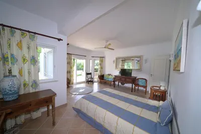 a bedroom with a bed and a living room at Villa Pinheiro Manso in Albufeira