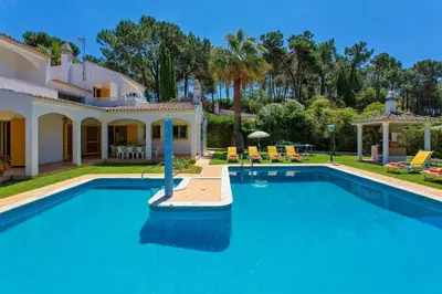 a large swimming pool in front of a house at Villa Miralago by Villa Plus in Vilamoura