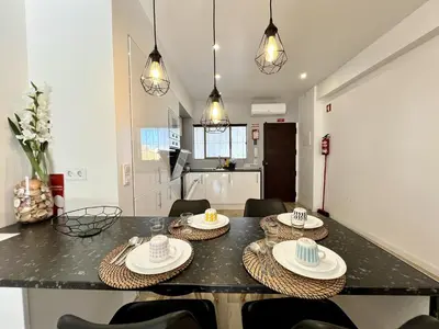 a kitchen and dining room with a table and chairs at Albufeira Central 7 by Homing in Albufeira
