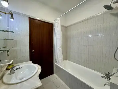 a kitchen with wooden cabinets and a white refrigerator at Albufeira Central 8 by Homing in Albufeira