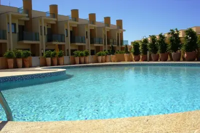 a swimming pool in front of a building at Casa Praia Patroves in Patroves