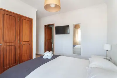 a bedroom with a bed with two towels on it at HostWise - Spacious & Sunny Flat - Loulé in Loulé