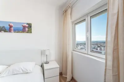 a bedroom with a bed and a large window at HostWise - Spacious & Sunny Flat - Loulé in Loulé