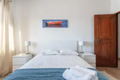 a bedroom with a bed with two night stands and two lamps at HostWise - Spacious & Sunny Flat - Loulé in Loulé