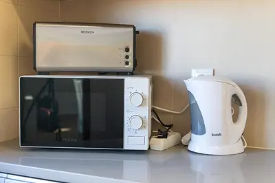 a microwave and a coffee maker on a counter at HostWise - Spacious & Sunny Flat - Loulé in Loulé