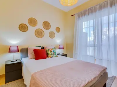 a bedroom with a large bed and a window at AL - Beachside Hideaway Quarteira in Quarteira