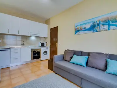a living room with a couch and a kitchen at AL - Beachside Hideaway Quarteira in Quarteira