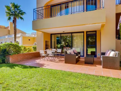 a house with a patio with a table and chairs at AL - Vila Sol Golfside Ground Floor in Vilamoura