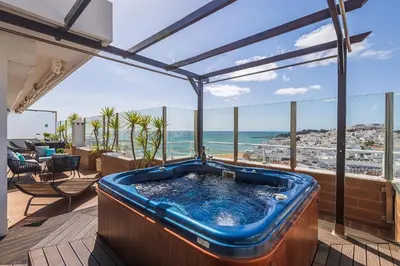 a hot tub on a deck with a view of the ocean at Phenthouse Monaco - Jacuzzi - City Center - Sea View in Albufeira