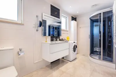 a bathroom with a sink and a washing machine at Phenthouse Monaco - Jacuzzi - City Center - Sea View in Albufeira