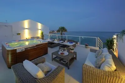 a balcony with a hot tub and two chairs at Casa Chanel - Ocean front with rooftop SPA Jacuzzi in Albufeira