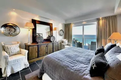 a bedroom with a large bed and a mirror at Casa Chanel - Ocean front with rooftop SPA Jacuzzi in Albufeira