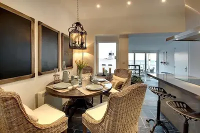 a kitchen and dining room with a table and chairs at Casa Chanel - Ocean front with rooftop SPA Jacuzzi in Albufeira