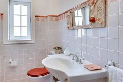 a bathroom with a sink and a toilet and a mirror at Villa Costa Rica in Galé