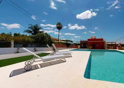 a pool with two lounge chairs next to a house at Villa Malmequer by FHR private in Quarteira