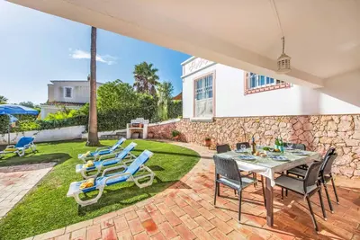 a patio with a table and chairs and a lawn at Casa Lorena in Guia