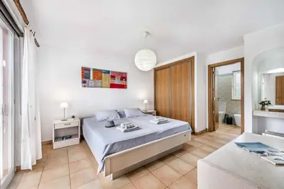 a bedroom with a large bed and a bathroom at Casa Lorena in Guia