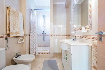a white bathroom with a toilet and a sink at Villa Marco in Galé