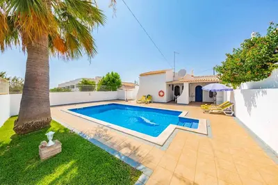 a villa with a swimming pool and a palm tree at Villa Marco in Galé