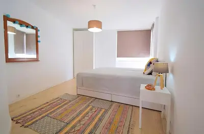 a white bedroom with a bed and a mirror at 3 min walking to the beach & Old Town by Algarve Dream Holidays in Albufeira