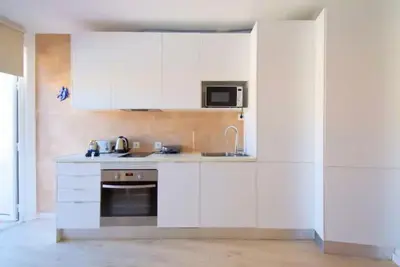a white kitchen with a sink and a microwave at 3 min walking to the beach & Old Town by Algarve Dream Holidays in Albufeira
