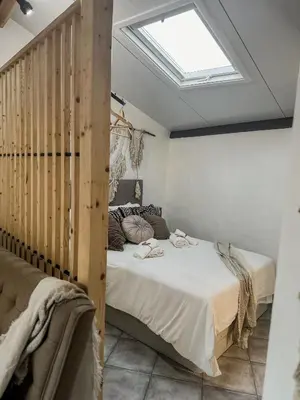 a bedroom with two beds and a skylight at Estúdio em Alte - KARMEA HOUSES in Alte