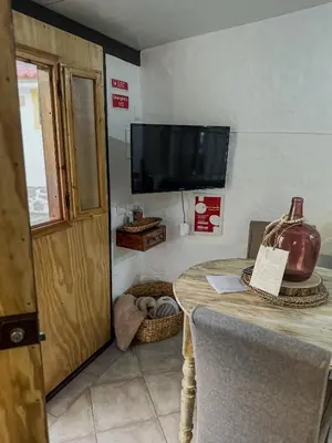 a room with a table and a flat screen tv at Estúdio em Alte - KARMEA HOUSES in Alte
