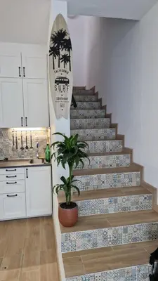 a staircase with a surfboard and a potted plant at Domek v srdci Fara in Faro