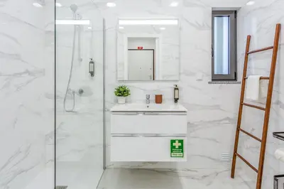 a white bathroom with a sink and a shower at Sublime and Bright 2 BDR Apartment by LovelyStay in Quarteira