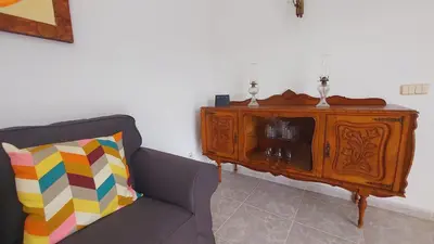 a living room with a couch and a wooden cabinet at Vivenda Atanázio By Férias com Sol in Loulé
