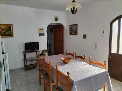 a dining room with a table and chairs and a television at Vivenda Atanázio By Férias com Sol in Loulé