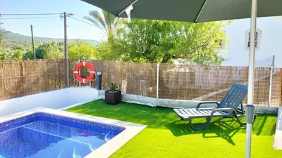 a swimming pool with a chair and an umbrella at Vivenda Atanázio By Férias com Sol in Loulé