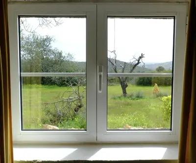 an open window with a view of a giraffe outside at Quinta Amarela XL by Portucasa in Loulé