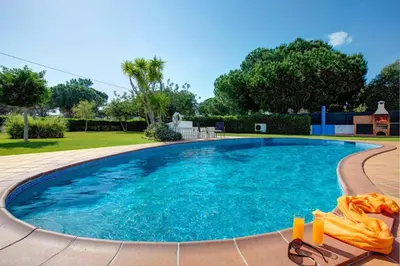 a large swimming pool with a pair of sunglasses next to it at Villa Sandra by Villa Plus in Olhos de Água
