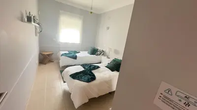 a room with two beds with green pillows on them at Solymar Apartment in Guia