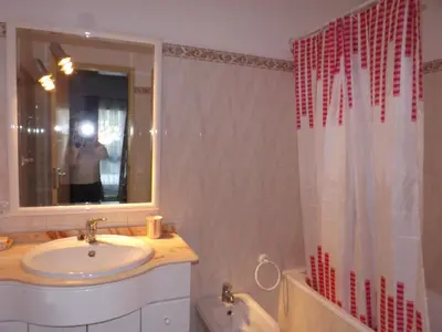 a man taking a picture of a bathroom with a sink at Casa Pinheiromar in Albufeira
